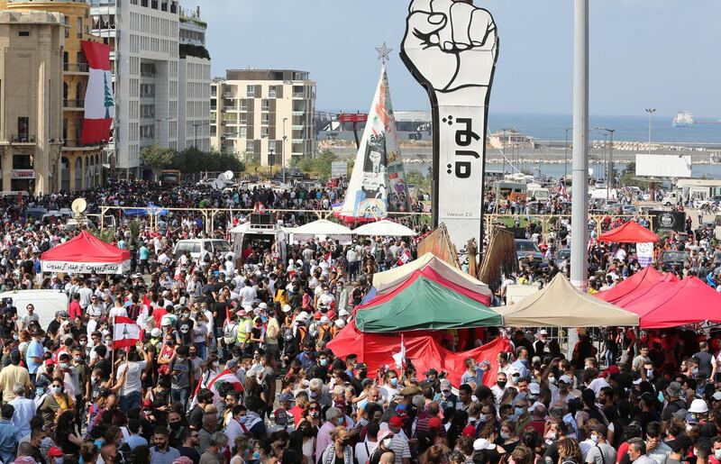 Lebanese people gather around a fist-shaped banner reading 'Revolution' as people gathered to protest against the political leaders and to call for those responsible over the explosion to be held accountable.  EPA