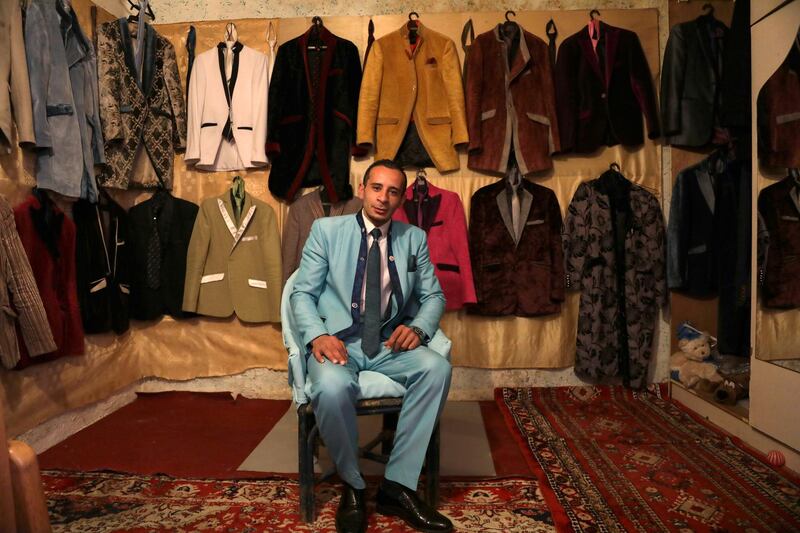 Ali Sarsour, an upholsterer, poses for a picture as he is surrounded by his suits made of leftover fabric from chairs at his home in Amman, Jordan. Reuters