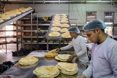 Workers pack Lebanese flat bread in Beirut. Inflation in Lebanon hit an annual 230 per cent in August last year. Bloomberg