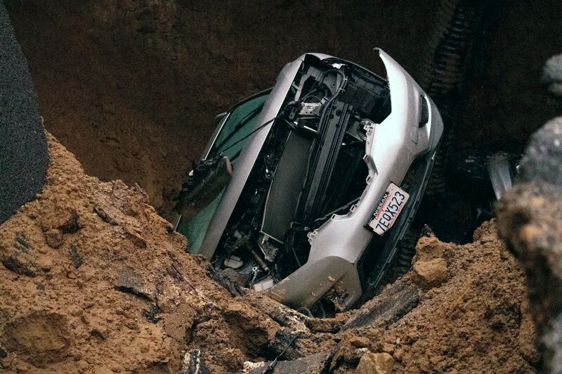 A woman and a young girl are recovering after being trapped inside one of the vehicles at the bottom of a large water-filled sinkhole on Monday night. The Orange County Register / AP