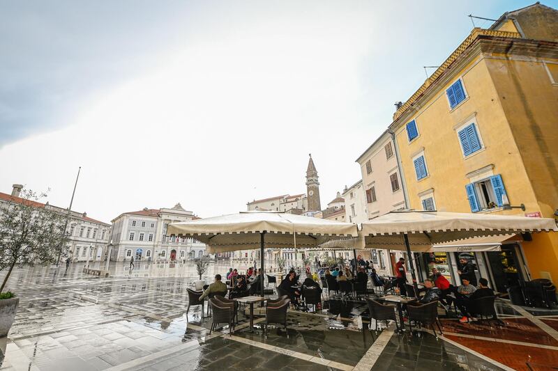 People sit at the terraces of cafes in the coastal city of Piran as Slovenia reopened cafe and restaurant terraces after six months following a decline in Covid-19 infections and deaths. AFP