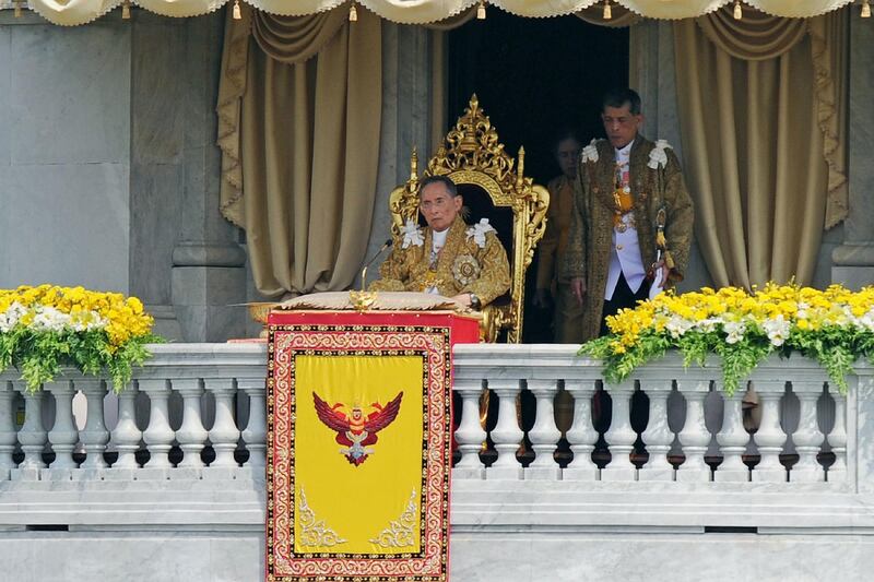 Thailand's former King Bhumibol Adulyadej sits on the throne after delivering an address with his son and Crown Prince Maha Vajiralongkorn looking on.  AFP