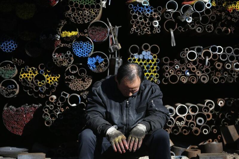 A worker naps on January 28, 2014, in front of steel products at a plant in Seoul. South Korean steelmaker Posco, backed by billionaire investor Warren Buffett, reported a smaller-than-expected 29 per cent gain in quarterly operating profit as the stronger won and weak demand sapped steel prices. Kim Hong-Ji / Reuters photo