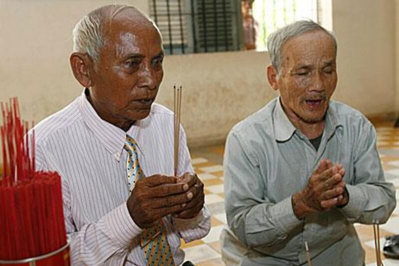Chum Mey, left, and Bou Meng, two survivors of Cambodia's Khmer Rouge prison S-21 pray ahead of the appeal verdict in the case against Kaing Guek Eav alias 'Duch', the former prison chief.