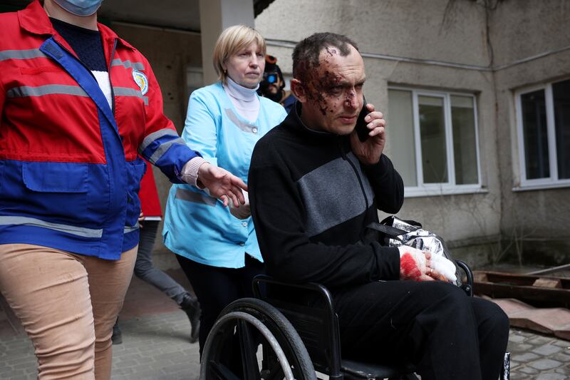 A man wounded in the air strikes at a nearby military complex is assisted by medical staff outside Novoiavorivsk District Hospital. Getty Images