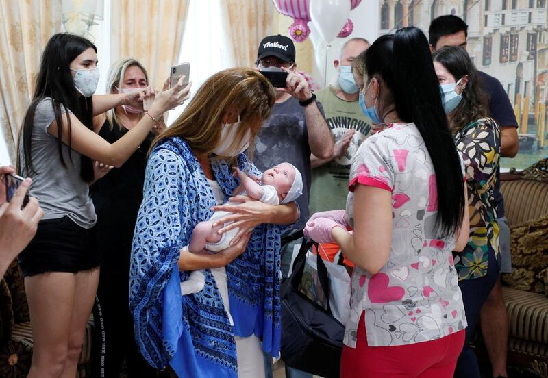 Participants of a ceremony surround Andrea Diez and Fernando Montero, Argentine citizens and parents of newborn Ignacio, during the couple's first meeting with their baby in the Hotel Venice owned by BioTexCom clinic in Kiev, Ukraine. The coronavirus lockdown prevented Andrea and Fernando from collecting their baby born to a surrogate mother, after almost all air travel was shut down. Reuters
