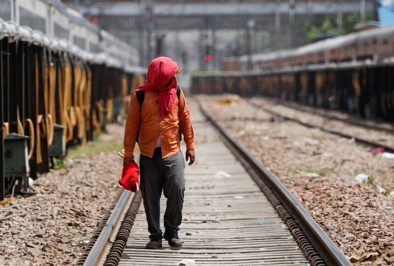 A railway worker shields his face from the sun as he inspects railway tracks in New Delhi, India, on Wednesday. Reuters
