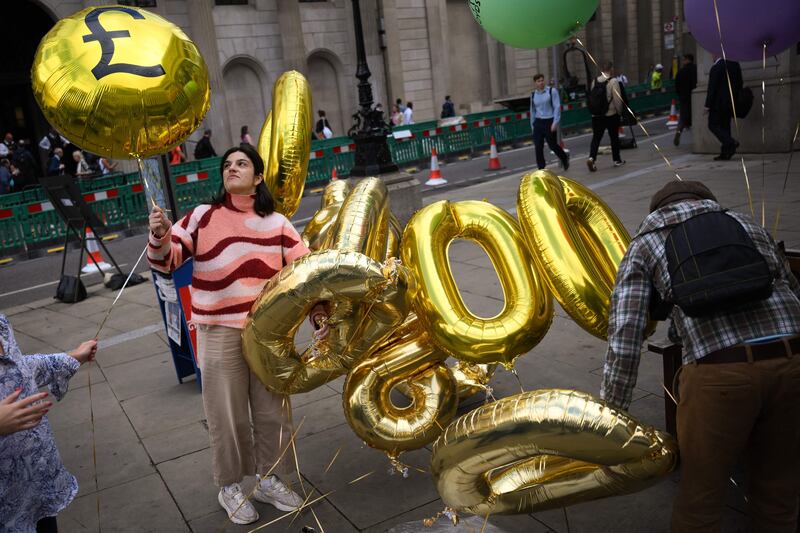 Protesters with balloons and placards representing the billions of pounds of profit earned by British banks. AFP