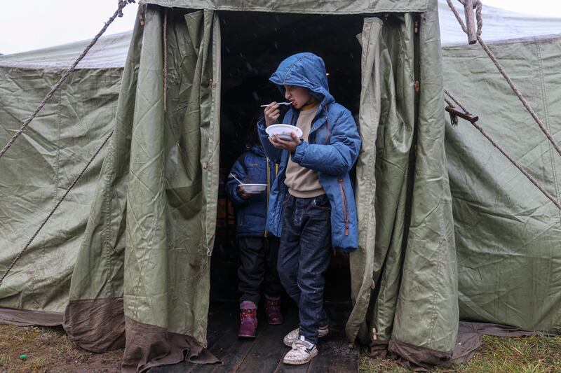 Boys leave the kitchen tent near the Bruzgi checkpoint. The EU believes Belarusian President Alexander Lukashenko has encouraged migrants to travel to the border in retaliation for sanctions imposed on Belarus over human rights abuses. EPA