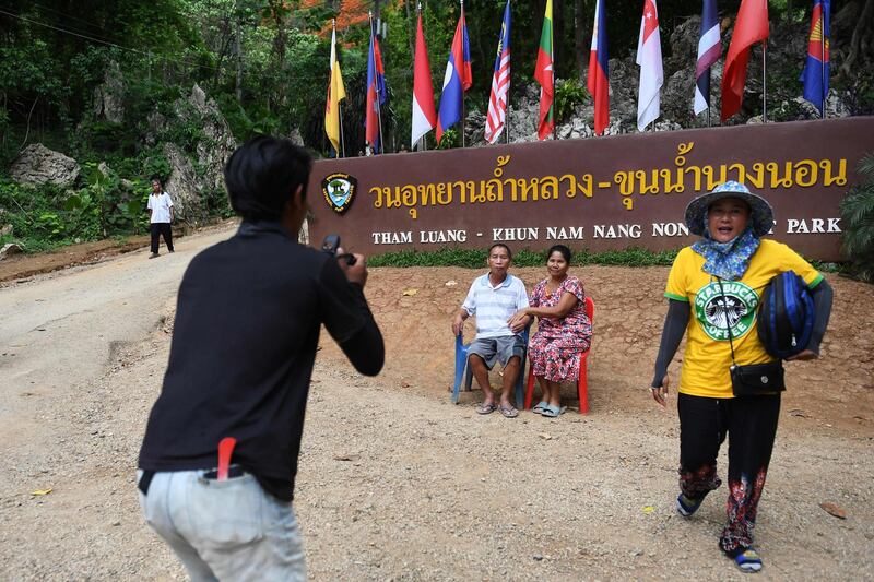 Visitors posing for photos near the entrance of the Tham Luang cave. AFP