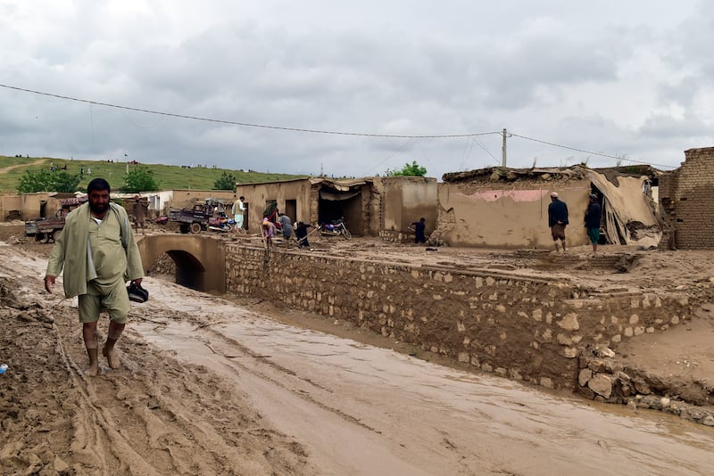 People clean up their damaged homes in Baghlan province. AP 