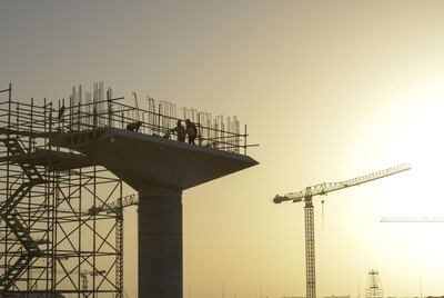Construction workers stand on a concrete supporting structure for the new metro rail link to the city at the building site for the World Expo 2020 exhibition in Dubai, United Arab Emirates, on Tuesday, Jan. 23, 2018. Much of the Arab world is mired in violence, poverty and unemployment, and yet in Dubai they���re��busy working on sending a probe to the red planet within three years. Photographer: Khushnum��Bhandari/Bloomberg