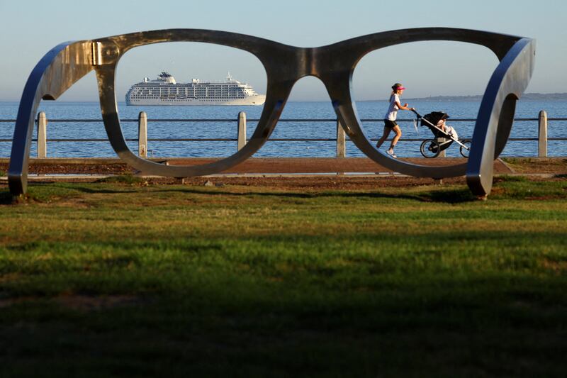 Seen through giant glasses, The World, an exclusive private residential ship, arrives in Cape Town, South Africa. Reuters