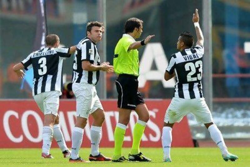 Juventus players argue with referee Gervasoni after Catania's Gonzalo Bergessio scored a goal.
