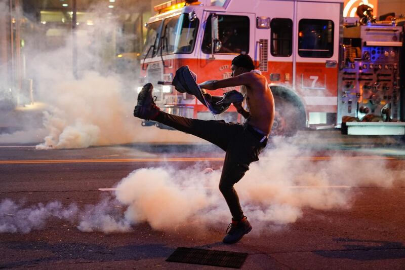 A man tosses back a tear gas canister during a protest on May 29, 2020 in Atlanta, Georgia. Getty Images/AFP