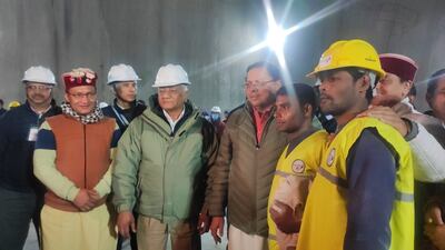 Chief Minister Pushkar Singh Dhami and Federal Minister VK Singh with the first worker to leave the tunnel after 16 days. Photo: DIPR