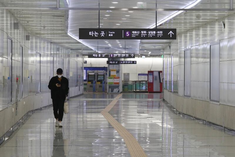 A man wearing a face mask walks alone at a subway station in Seoul, South Korea, Sunday, March 1, 2020. The coronavirus has claimed its first victim in the United States as the number of cases shot up in Iran, Italy and South Korea and the spreading outbreak shook the global economy. (AP Photo/Ahn Young-joon)