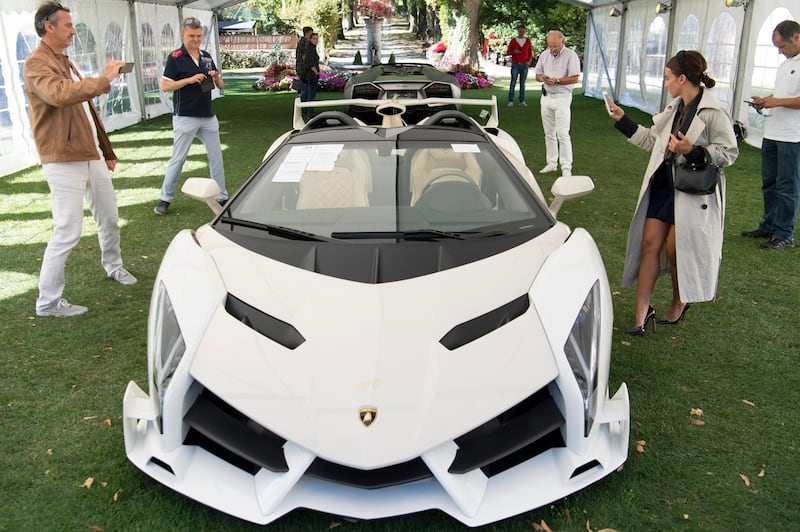 People look at a 2014 Lamborghini Veneno Roadster, part of some 25 luxury cars owned by the son of the Equatorial Guinea's President Teodoro Obiang that were seized in a money-laundering probe. Laurent Gillieron/Keystone via AP