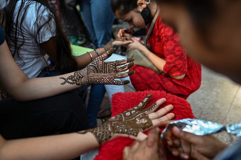 Women get their hands decorated with henna on the eve of the Karva Chauth festival. AFP