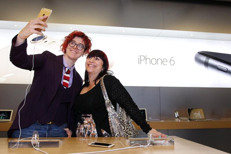 Customers Alice Clarke, left, and Katie Cincotta take a “selfie” photograph using an iPhone 6 Plus in Sydney. Lisa Maree Williams / Bloomberg