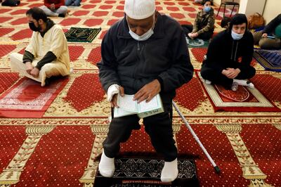 A Muslim reads the Quran before an evening prayer called "tarawih" during the first evening of the holy fasting month of Ramadan at Chicago's Muslim Community Center on Monday, April 12, 2021. (AP Photo/Shafkat Anowar)