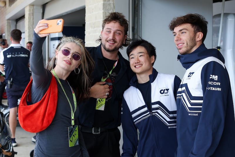 Pierre Gasly of France and Scuderia AlphaTauri and Yuki Tsunoda of Japan and Scuderia AlphaTauri meet Eve Hewson and John Hewson in the garage prior to the F1 Grand Prix of USA. AFP