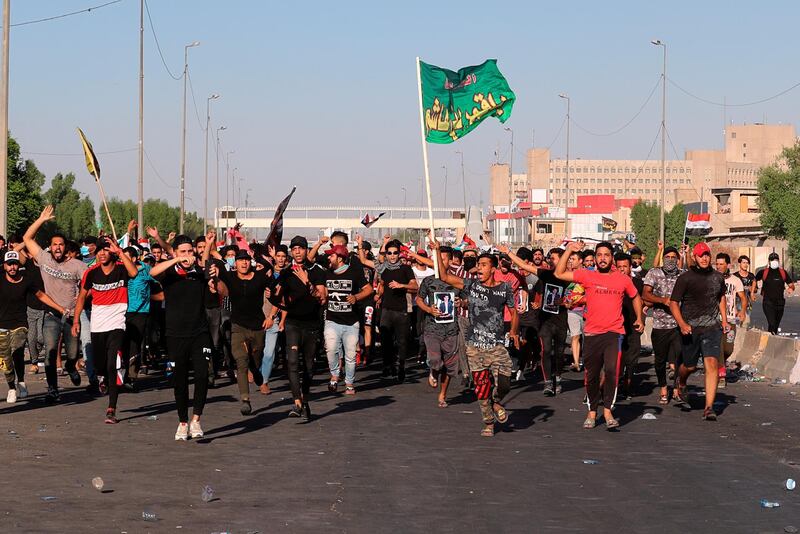 Anti-government protesters chant slogans during a demonstration in Baghdad, Iraq.  AP