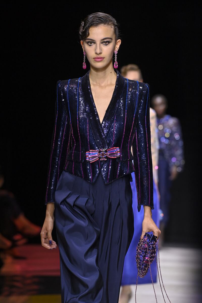 Al Zuhair at the Giorgio Armani Prive haute couture show, wearing a sequined tailored jacket over front-pleat satin trousers. Getty