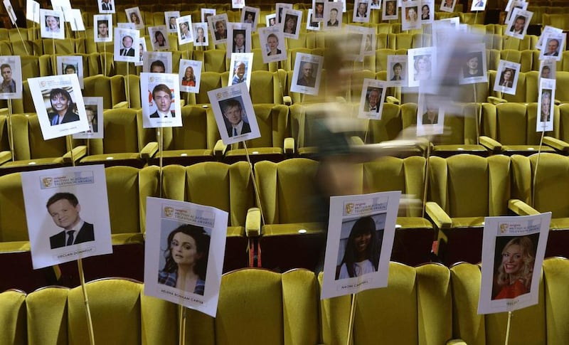 An assistant places guest seating position sticks during a rehearsal for the British Academy Television Awards at the Theatre Royal in central London May 14, 2014. The awards take place on Sunday May 18. Reuters