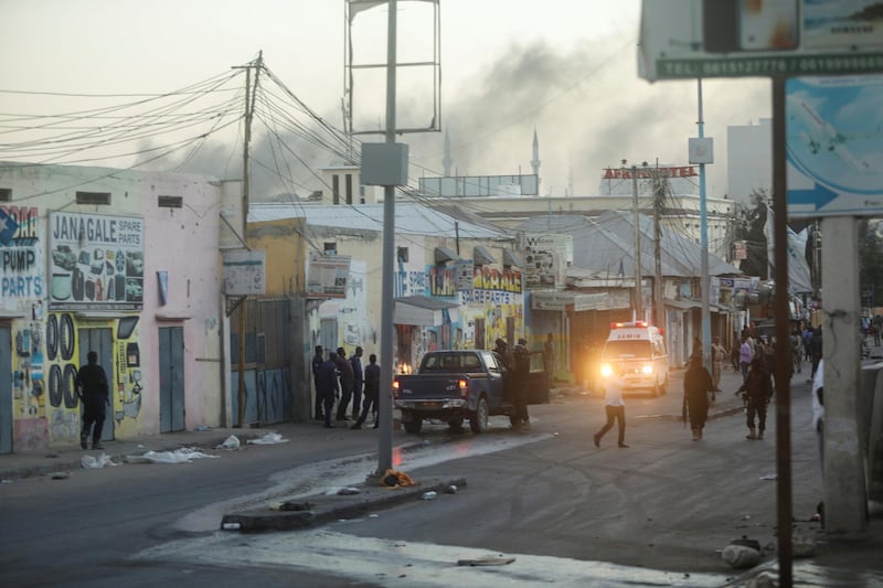 Somali security officers secure the scene of a car bomb explosion in the Kilometre 4 area of Mogadishu, Somalia on January 31, 2021 as paramedics await to rescue the injured . Reuters