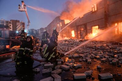 Ukrainian firefighters extinguish a blaze at a warehouse after a bombing in Kyiv.  AP