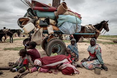 A Sudanese family that fled the conflict in Murnei in Sudan's Darfur region sit beside their belongings while waiting to be registered by UNHCR upon crossing the border between into Chad. Reuters
