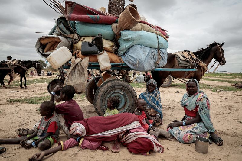 A Sudanese family who fled the conflict in the Darfur region wait with their belongings to be registered by the UNHCR, upon crossing the border between Sudan and Chad in Adre, Chad, on July 26, 2023. Reuters