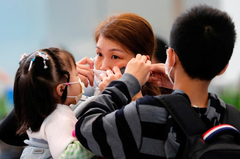 A woman adjusts her mask at the Hong Kong West Kowloon High Speed Train Station. Reuters