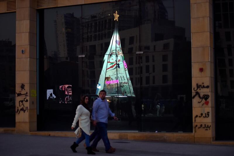 An illuminated Christmas tree made from protest banners by Lebanese anti-government demonstrators is reflected in a shop window at Martyrs Square in Beirut.  EPA