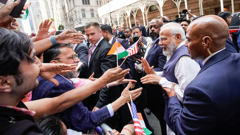 Mr Modi greets supporters as he arrives in New York. AP
