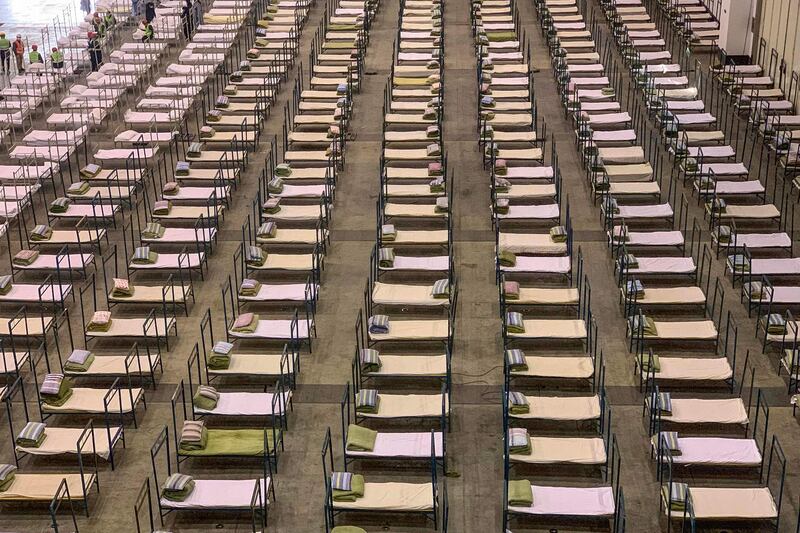 Workers set up beds at an exhibition centre that was converted into a hospital in Wuhan in China's central Hubei province.  AFP