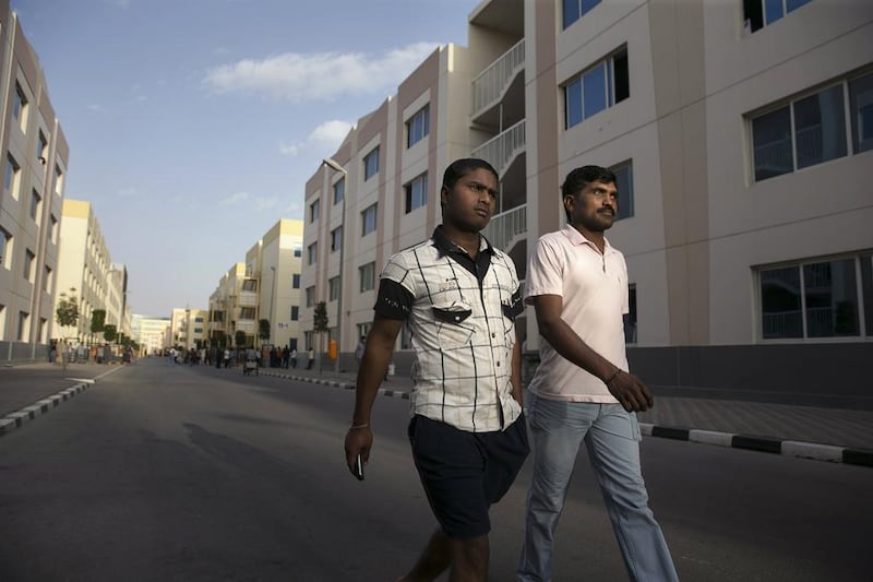 Workers’ Village residents Raja Shekar, left, and his roommate Rajanna Neelam, both from India, walk through the compound in Mussaffah. Silvia Razgova / The National