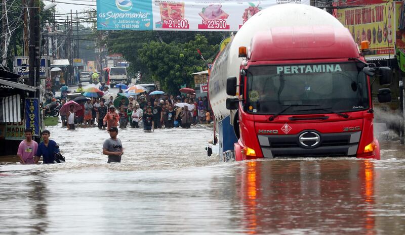 A truck drives through a flooded road at Jatibening on the outskirt of Jakarta, Indonesia, Wednesday, Jan. 1, 2020. Severe flooding hit Indonesia's capital just after residents celebrating New Year's Eve, forcing a closure of an airport and thousands of inhabitants to flee their flooded homes. (AP Photo/Achmad Ibrahim)