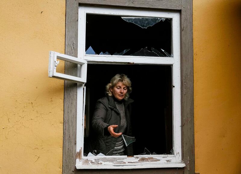 A local resident looks out of a broken window in the settlement of Druzhba, near the scene of explosions at a defence ministry ammunition depot in the eastern Chernigov region, Ukraine. Gleb Garanich/Reuters