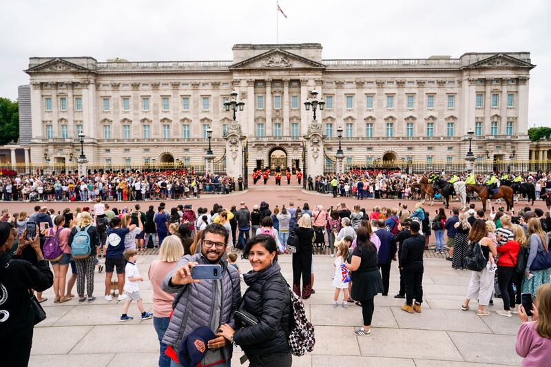 Tourists take a selfie in front of the Changing the Guard ceremony at Buckingham Palace. AP Photo