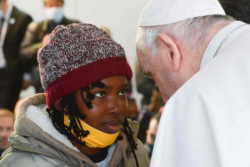 Pope Francis with a young migrant on the island of Lesbos. AFP