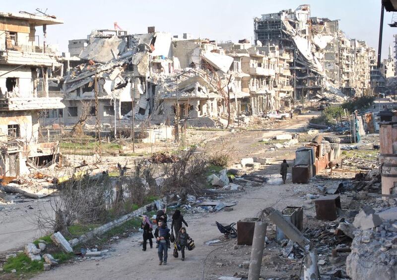 Civilians leave the  the besieged Syrian city of Homs as Syria's regime and rebels accused each other of violating a truce. Bassel Tawil / AFP

