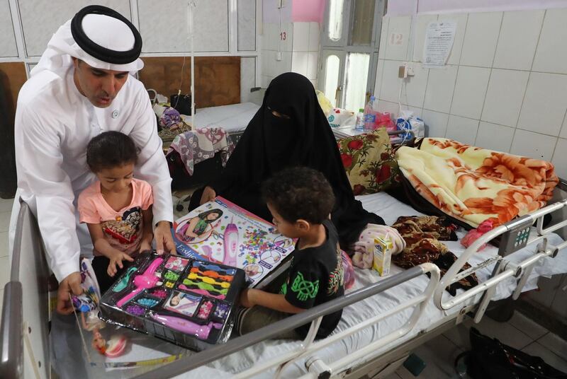 The UAE's Humanitarian Operations Director for Yemen, Saeed Al Kaabi, left, presenting gifts to Yemeni children diagnosed with malnutrition at a hospital in Mukalla. AFP.