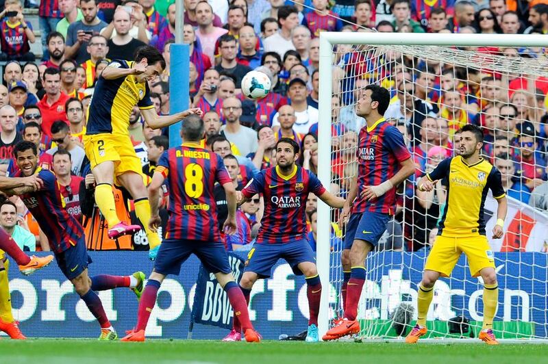 Diego Godin, left, of Atletico Madrid scores the goal that won his team the Spanish Primera Liga title during their match against Barcelona at Camp Nou on May 17, 2014 in Barcelona, Spain. David Ramos / Getty Images