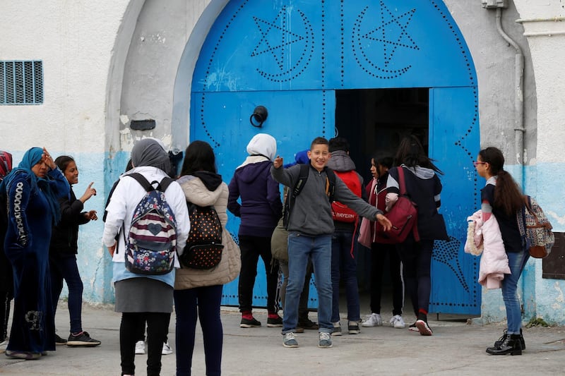 Parents and students are seen in front of a high school in Tunis, Tunisia March 9, 2020, after the health minister announced that a scheduled school holiday will be brought forward to Thursday from next Monday as a measure against the coronavirus. Reuters