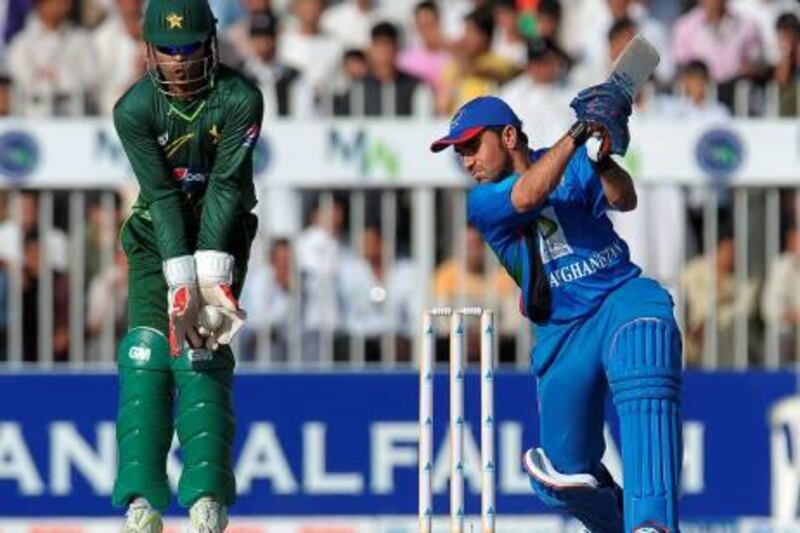Pakistan's wicketkeeper Umar Akmal (L) takes a catch to dismiss Afghanistan's cricketer Karim Sadiq during the first One Day International (ODI) match between Pakistan and Afghanistan at the Sharjah Cricket Stadium in Sharjah on February 10, 2012. AFP PHOTO/ LAKRUWAN WANNIARACHCHI

 *** Local Caption ***  838544-01-08.jpg