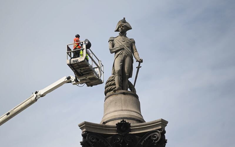 Workers get a close-up look at the statue on top of Nelson's Column in Trafalgar Square, London, during an inspection of the monument on Tuesday. EPA