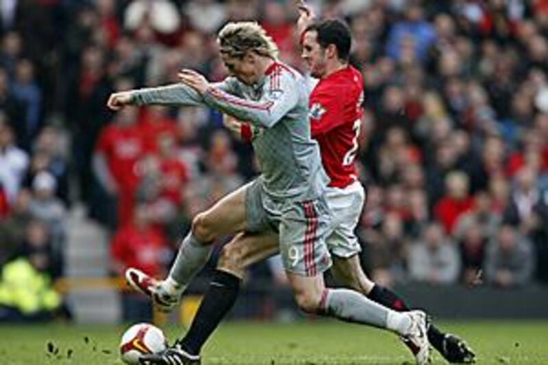 Manchester United's John O'Shea, right, fights for the ball with Liverpool's Fernando Torres.