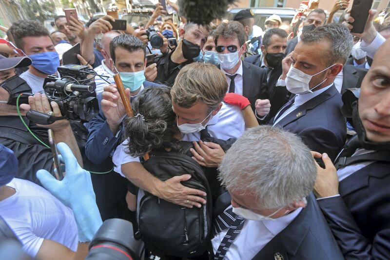A Lebanese youth hugs French President Emmanuel Macron during a visit to the Gemmayzeh neighbourhood, which has suffered extensive damage due to a massive explosion in the Lebanese capital, on August 6, 2020. French President Emmanuel Macron visited shell-shocked Beirut, pledging support and urging change after a massive explosion devastated the Lebanese capital in a disaster that has sparked grief and fury. / AFP / -
